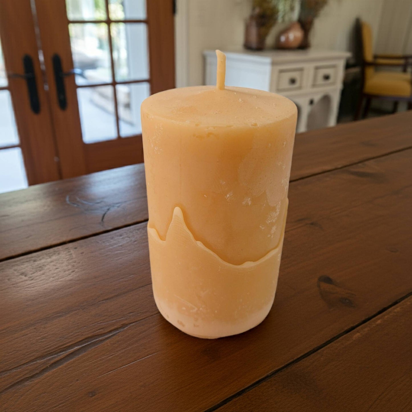 Beeswax candle on a wooden table with a blurred background