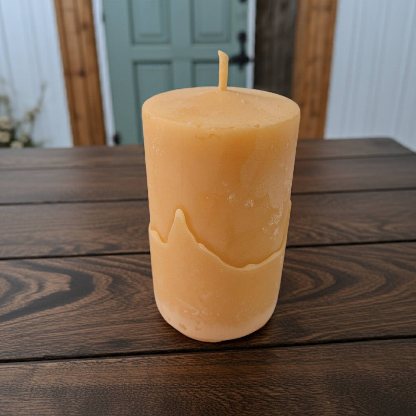 Beeswax candle on a wooden surface with a blurred background