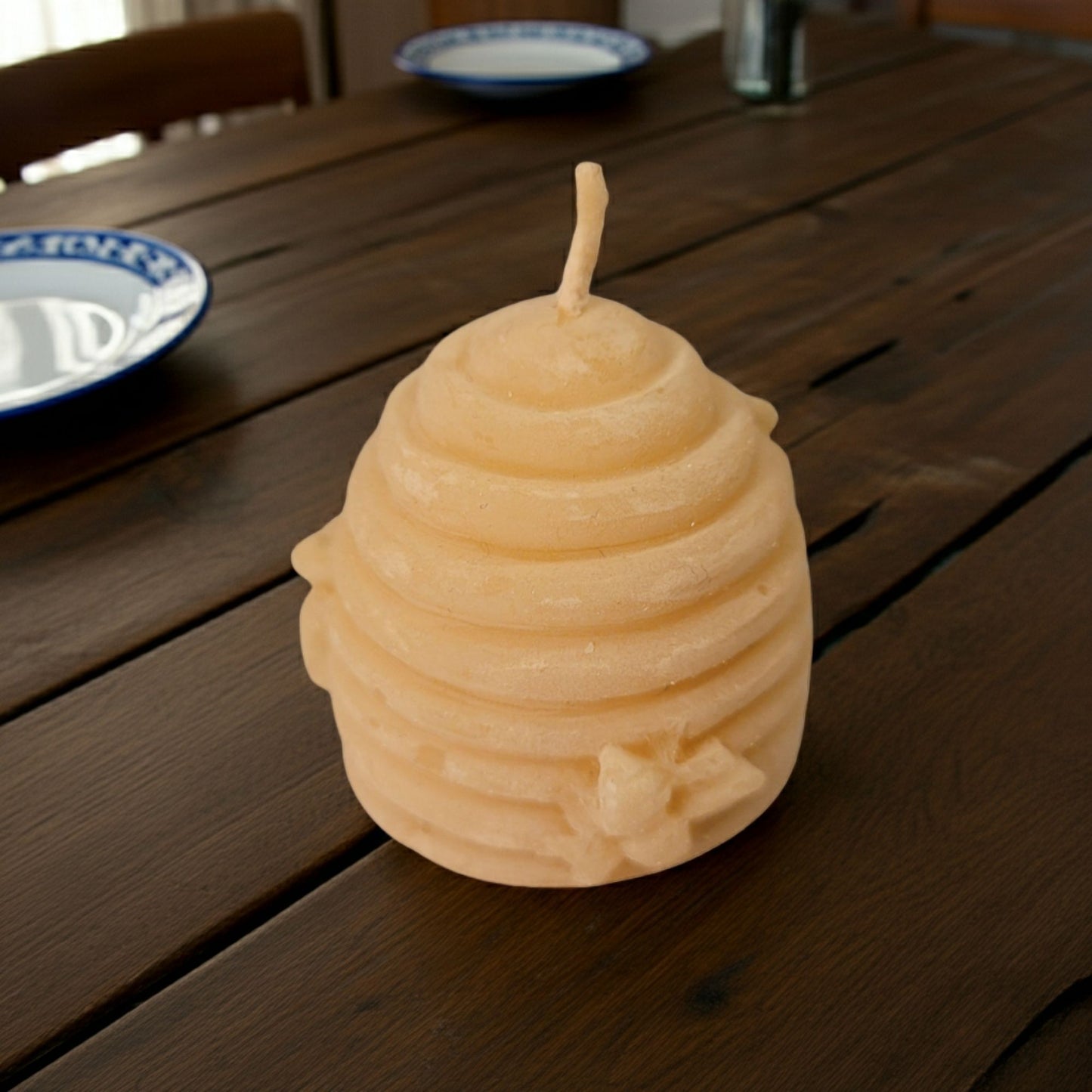 Beeswax candle shaped like a beehive on a wooden table