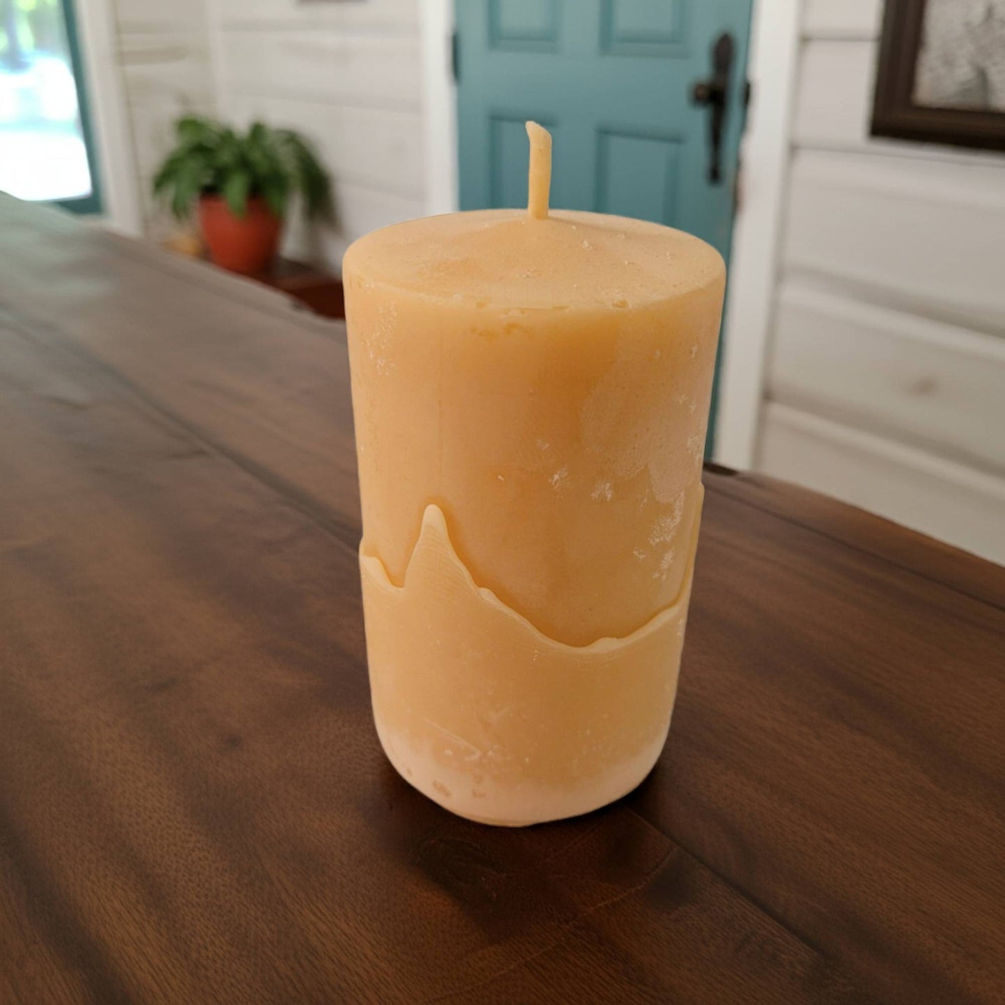 beeswax candle on a wooden table with a blurred background