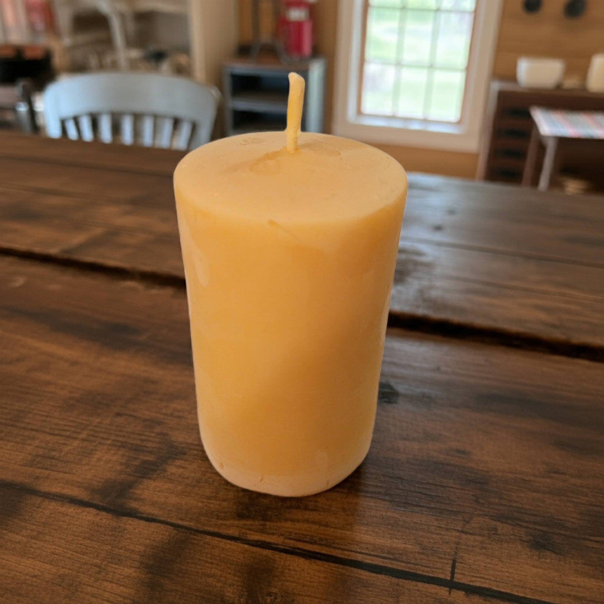 Beeswax candle on a wooden table with a blurred background