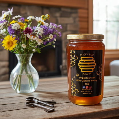 Jar of honey from Sticky Bee Apiary on a wooden table with flowers and keys in the background.