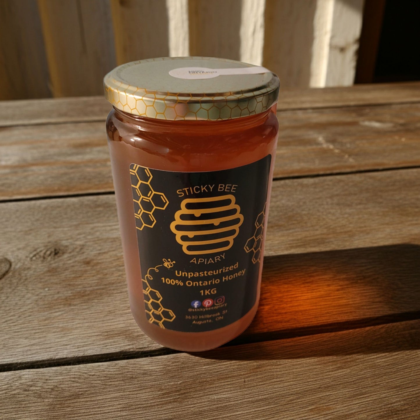 Jar of Sticky Bee Apiary honey on a wooden surface