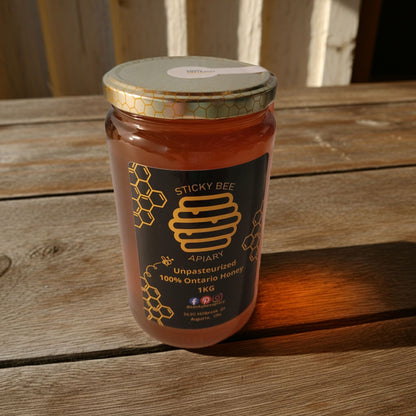 Jar of Sticky Bee Apiary honey on a wooden surface