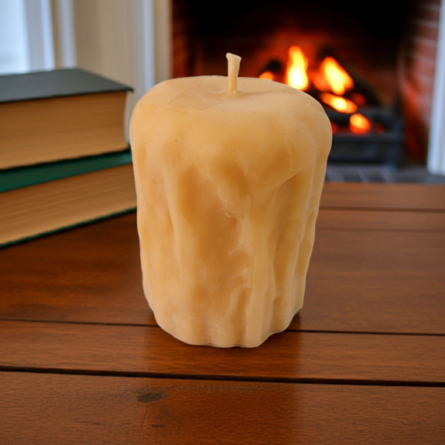 Rustic Pillar Candle on a wooden surface with a fireplace in the background