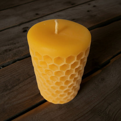 Pure beeswax candle on a wooden surface