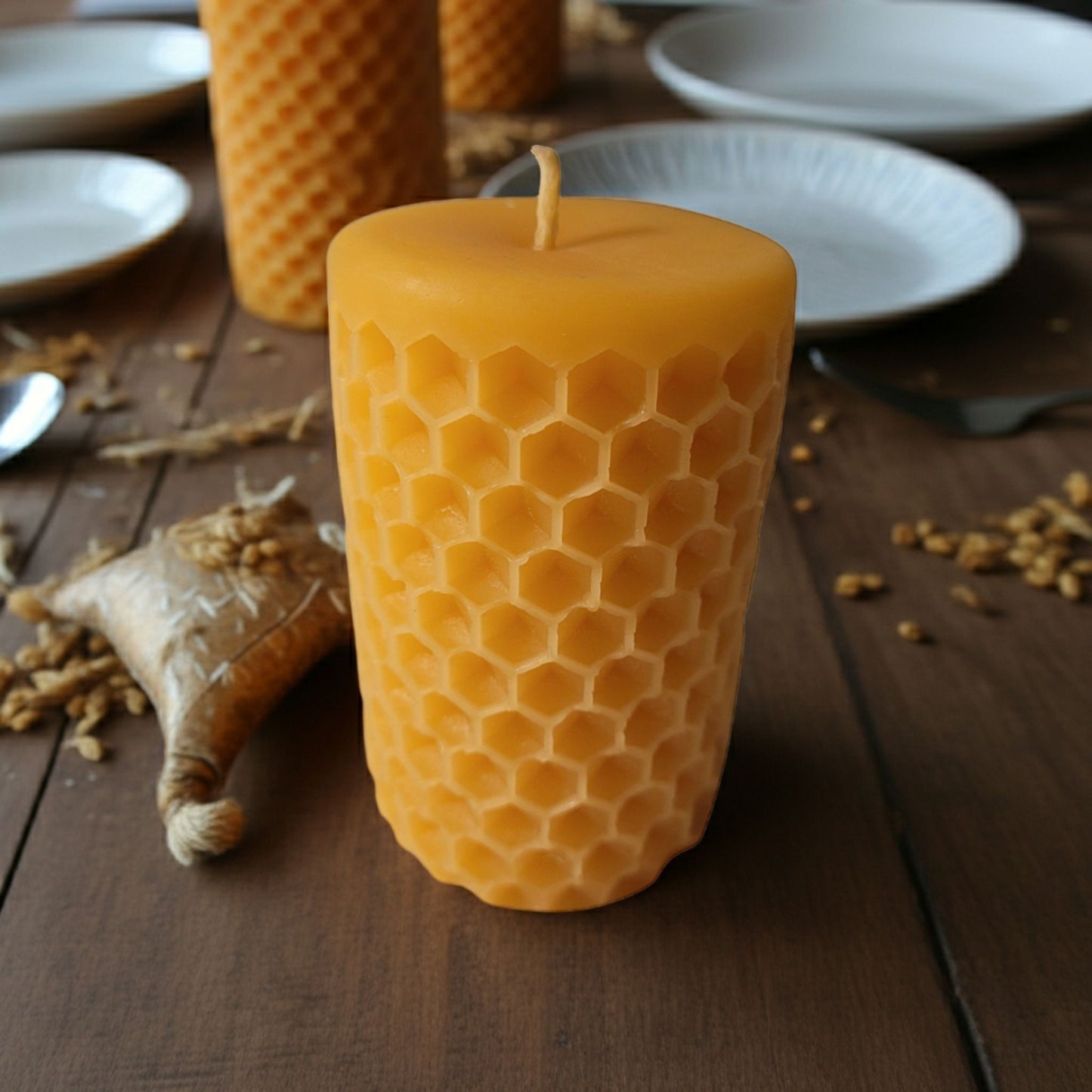 Beeswax candle with honeycomb pattern on a wooden surface