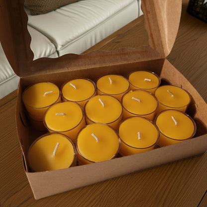 Box of yellow candles on a wooden surface with a beige couch in the background