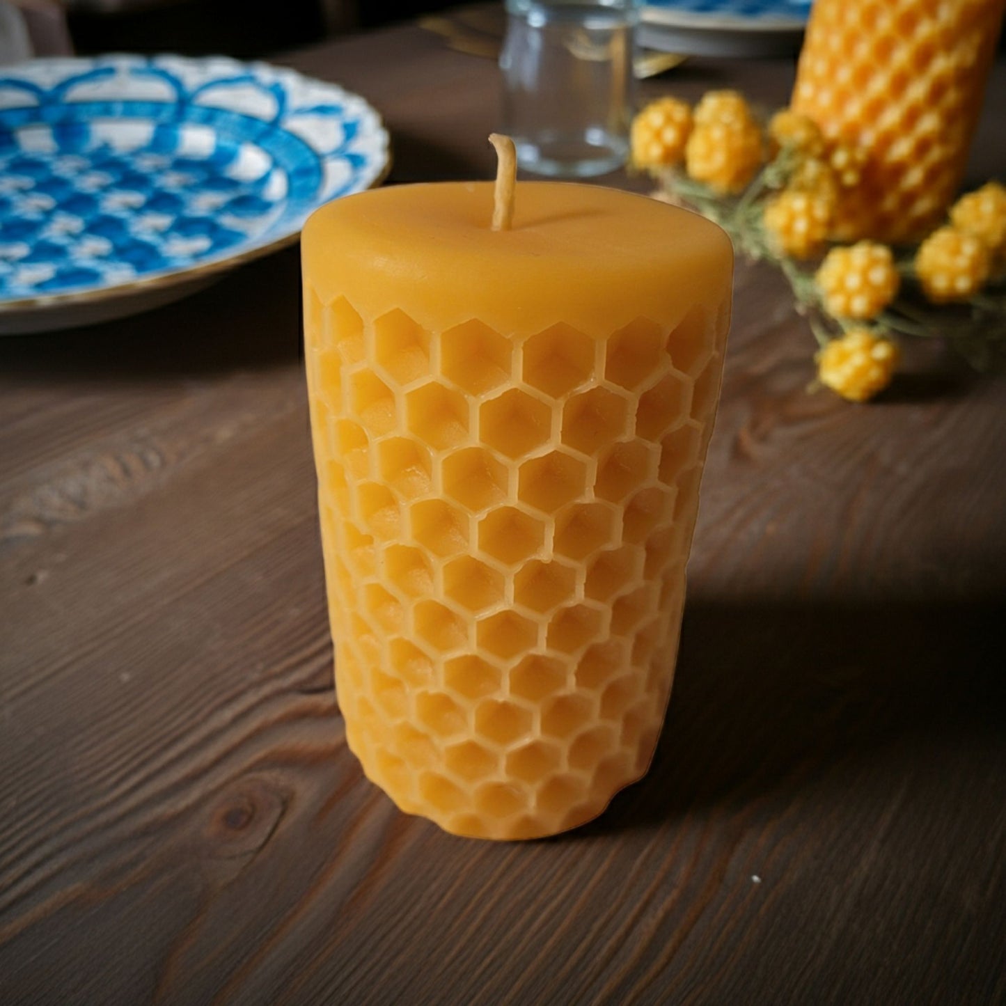 Beeswax candle with honeycomb pattern on a wooden surface