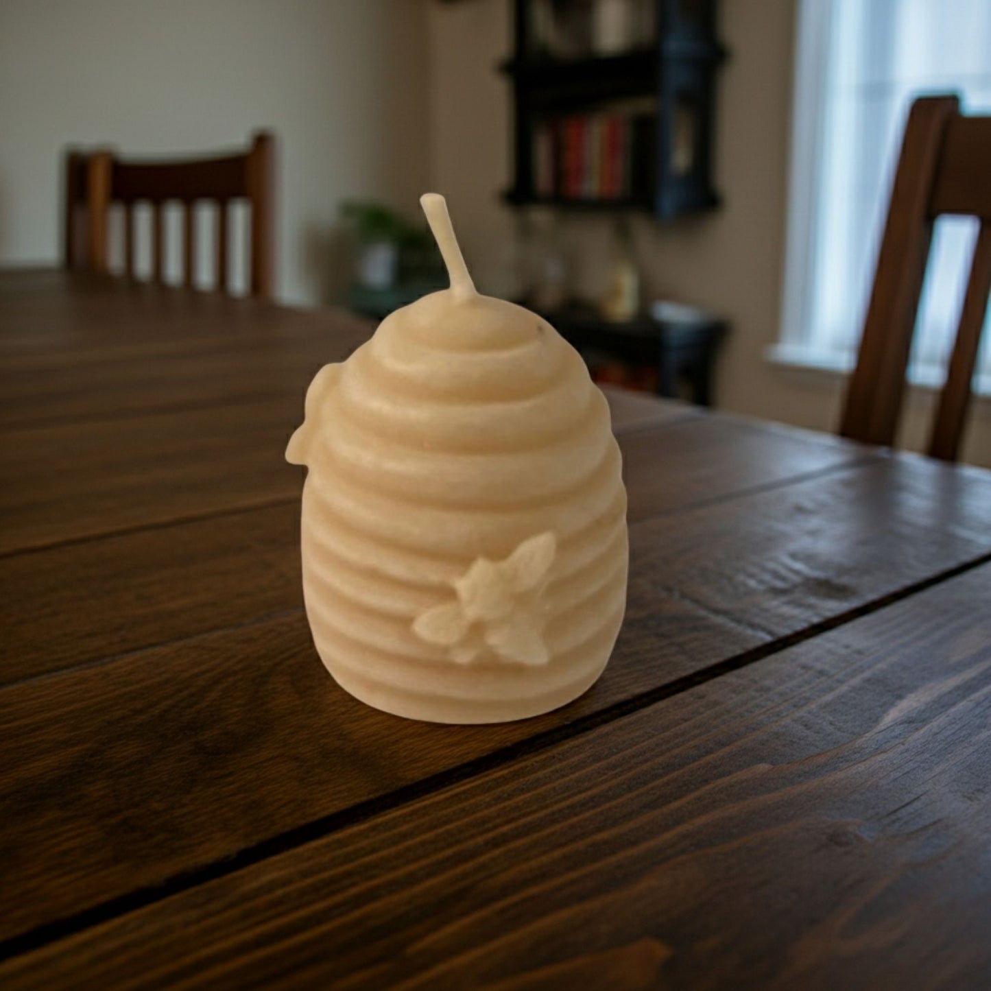 Beehive-shaped candle on a wooden table with a blurred background
