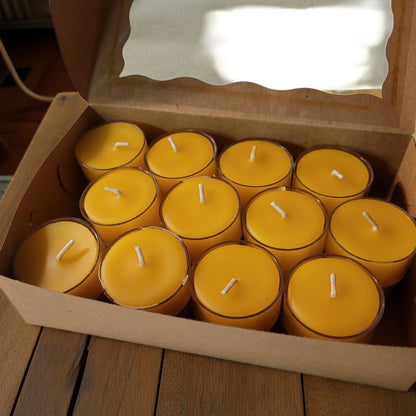 Box of yellow candles on a wooden surface