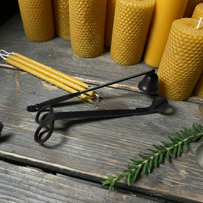 Beeswax candles and candle care kit on a wooden surface with a branch of rosemary.