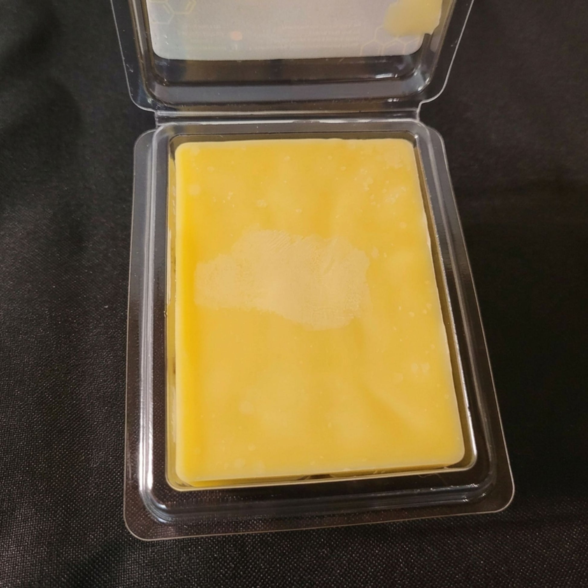 An open package of pure beeswax sweet orange scented wax melt from sticky bee apiary.