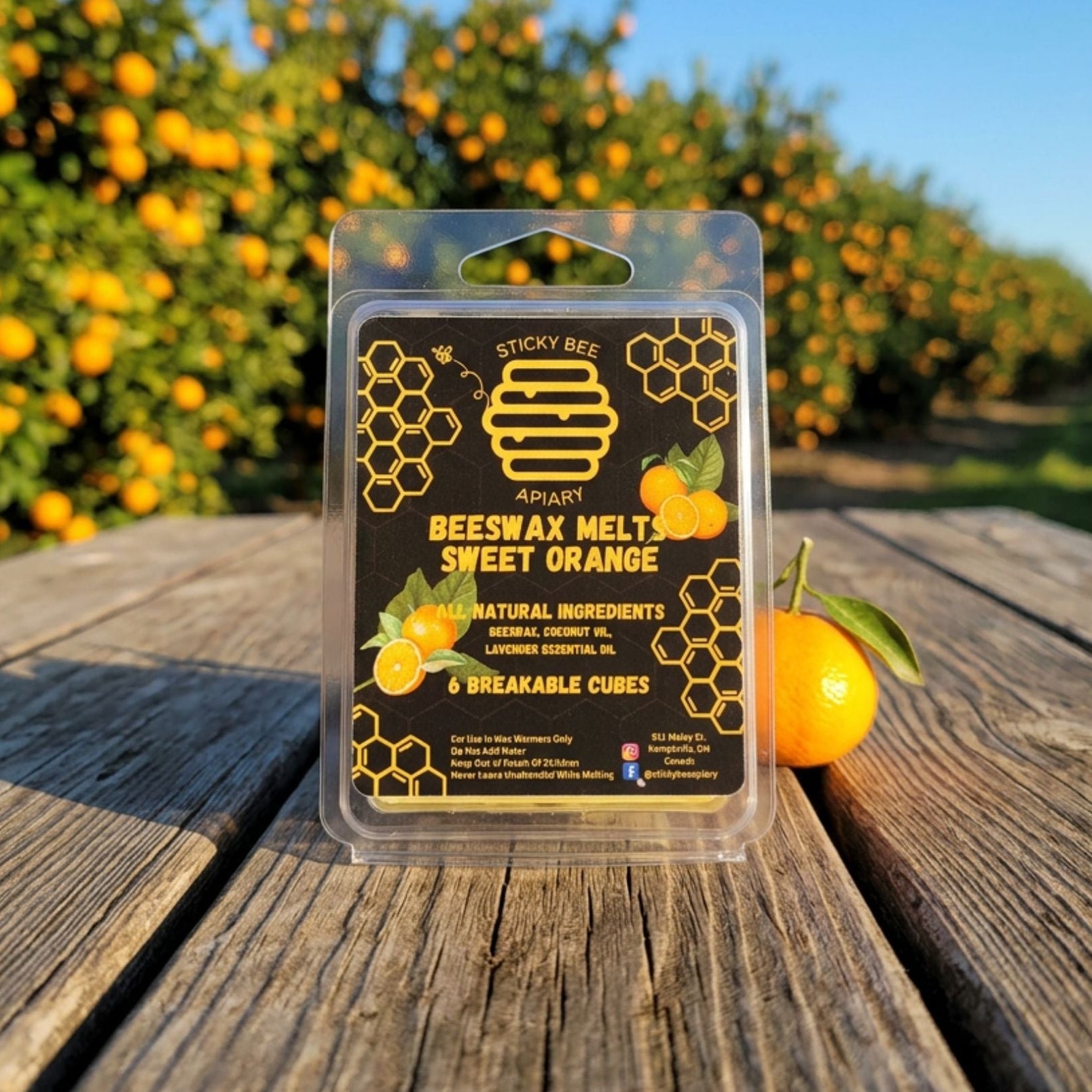 Beeswax melt package with sweet orange scent on a wooden surface with an orange tree background.